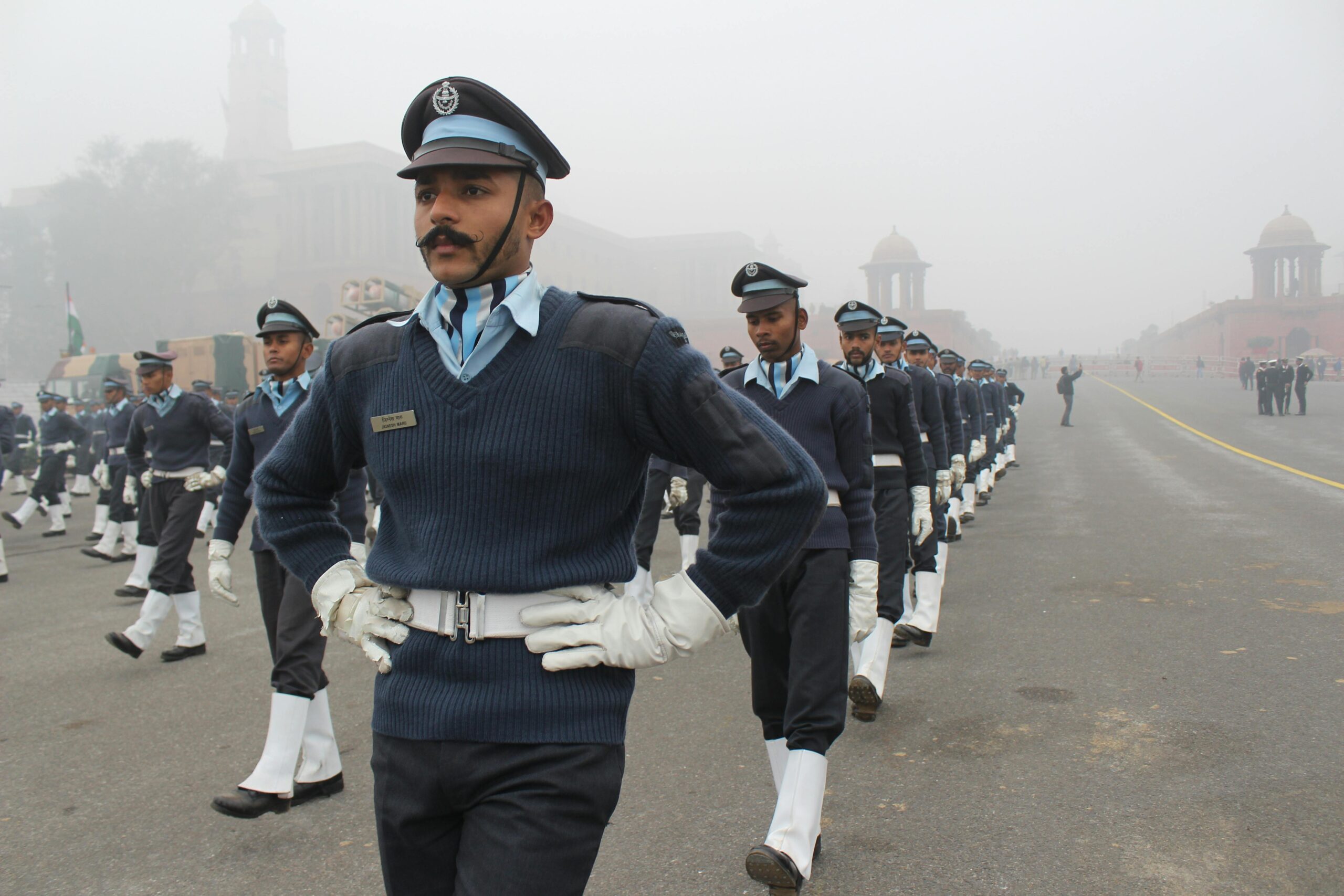 Indian soldiers in uniform marching during a foggy parade ceremony.