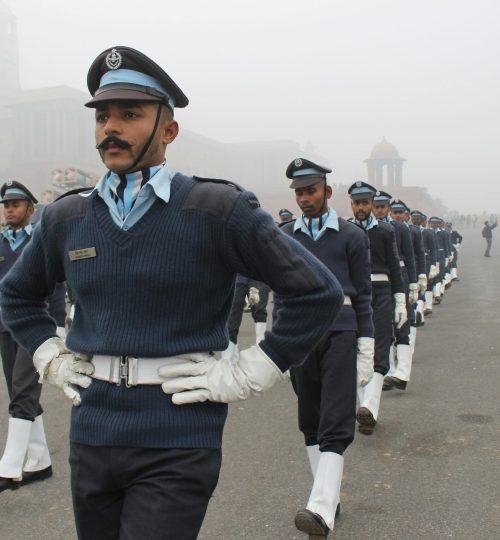 Indian soldiers in uniform marching during a foggy parade ceremony.